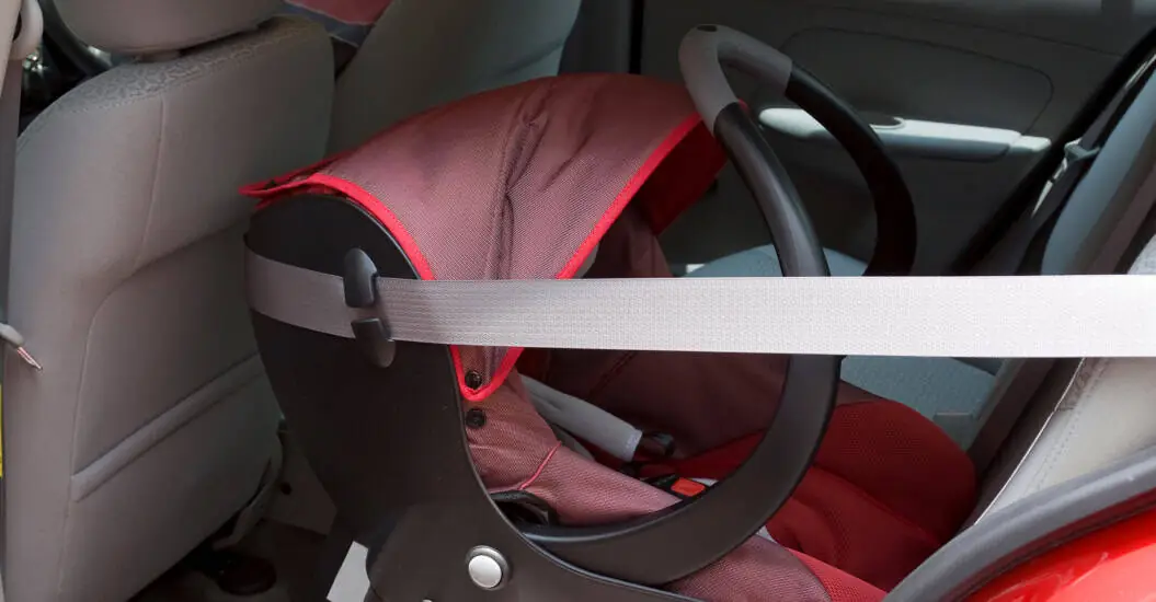 Infants reverse facing car seat belted into the backseat of a car