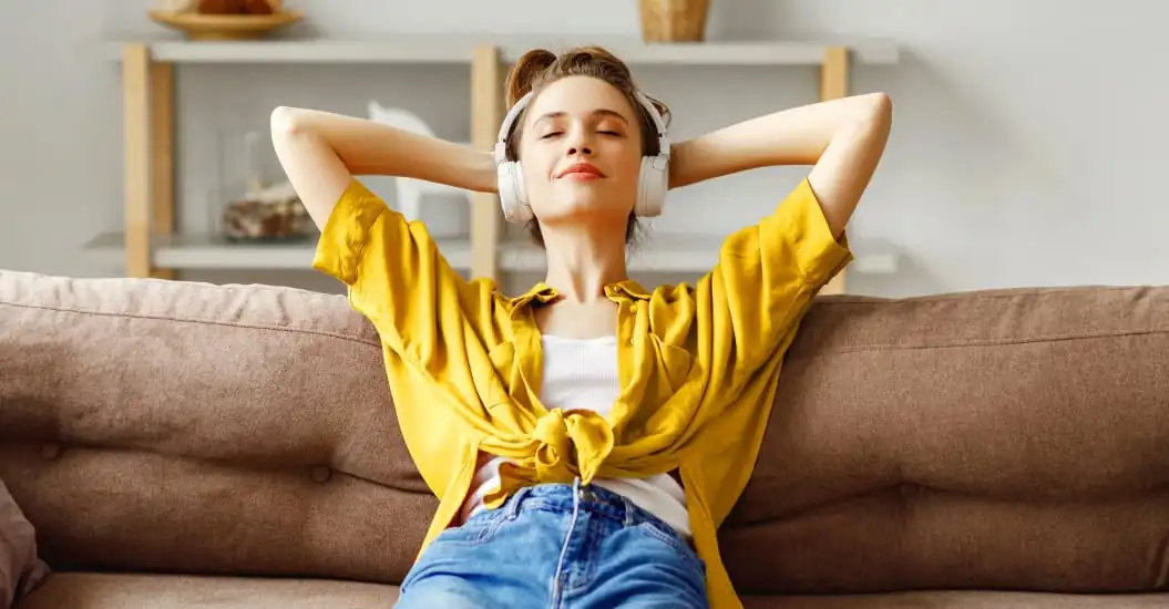 Woman relaxing on couch with her headphones on