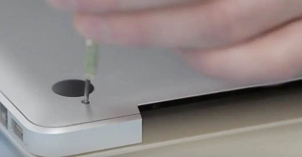 Repairer opening a computer with a screwdriver