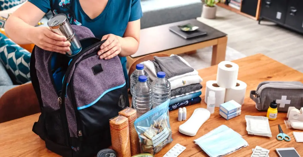 Woman packing the essentials into her emergency grab bag