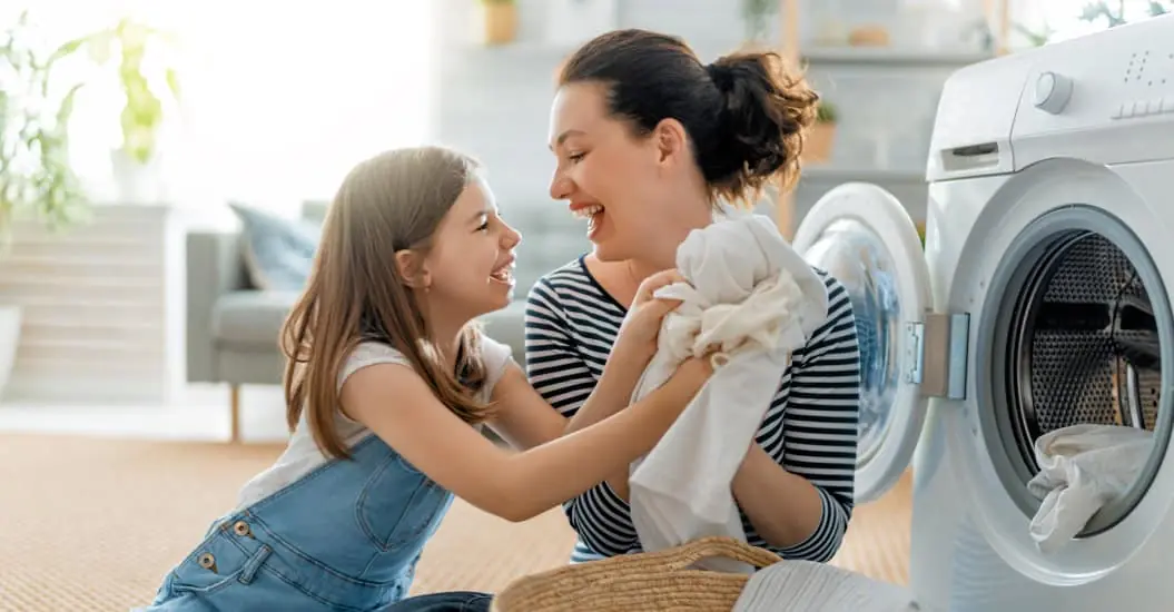 Mother and daughter happily folding laundry