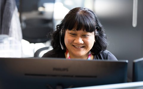 Woman smiles while working at her laptop