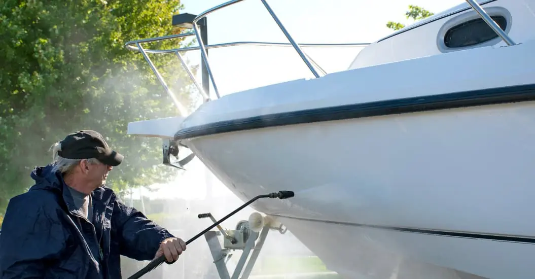 Boat owner cleaning boat after having it in storage