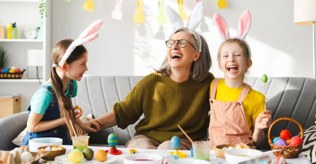 Grandma and her grandaughters doing Easter crafts dressed up as bunnies